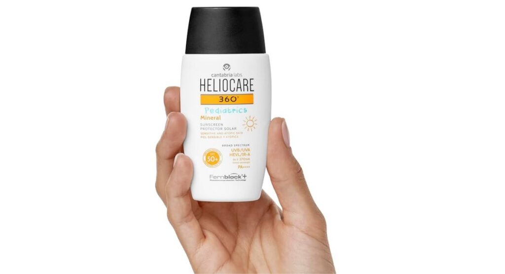 Hand holding Heliocare 360 Pediatrics Mineral Sunscreen SPF50 50ml bottle showing product details