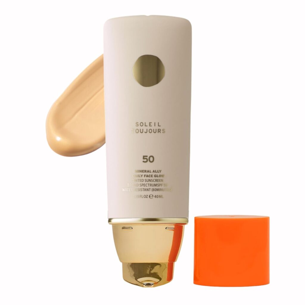 Soleil Toujours Mineral Ally Daily Face Glow tinted sunscreen SPF 50 in white tube with gold pump cap and orange accent, showing beige product swatch, water resistant for 80 minutes, 1.35 fl. oz./40ml.