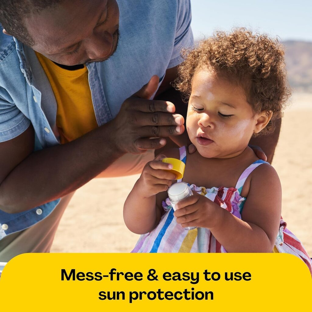 Parent applying Hello Bello sunscreen to toddler at beach, demonstrating mess-free application in Hello Bello sunscreen reviews