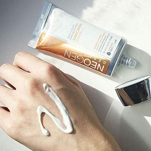 Close-up of Neogen sunscreen being applied to hand, showing white cream texture of the SPF50 formula.