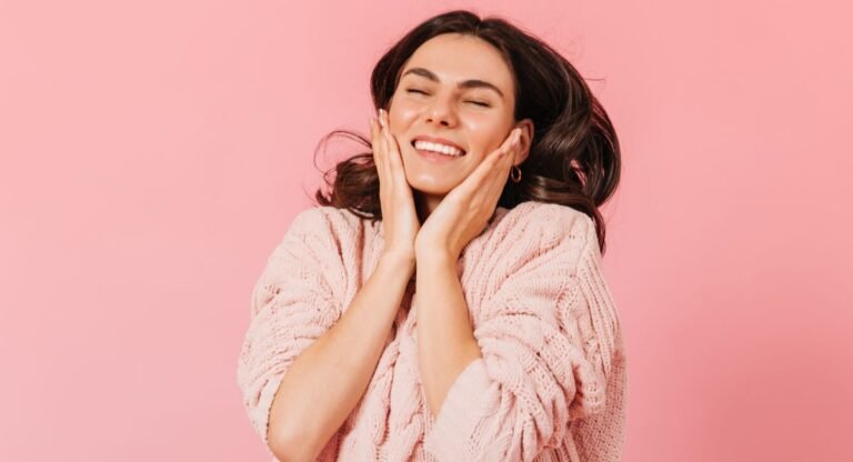 Woman with radiant skin smiling after using Heliocare 360 fluid cream SPF50 skin healthcare product